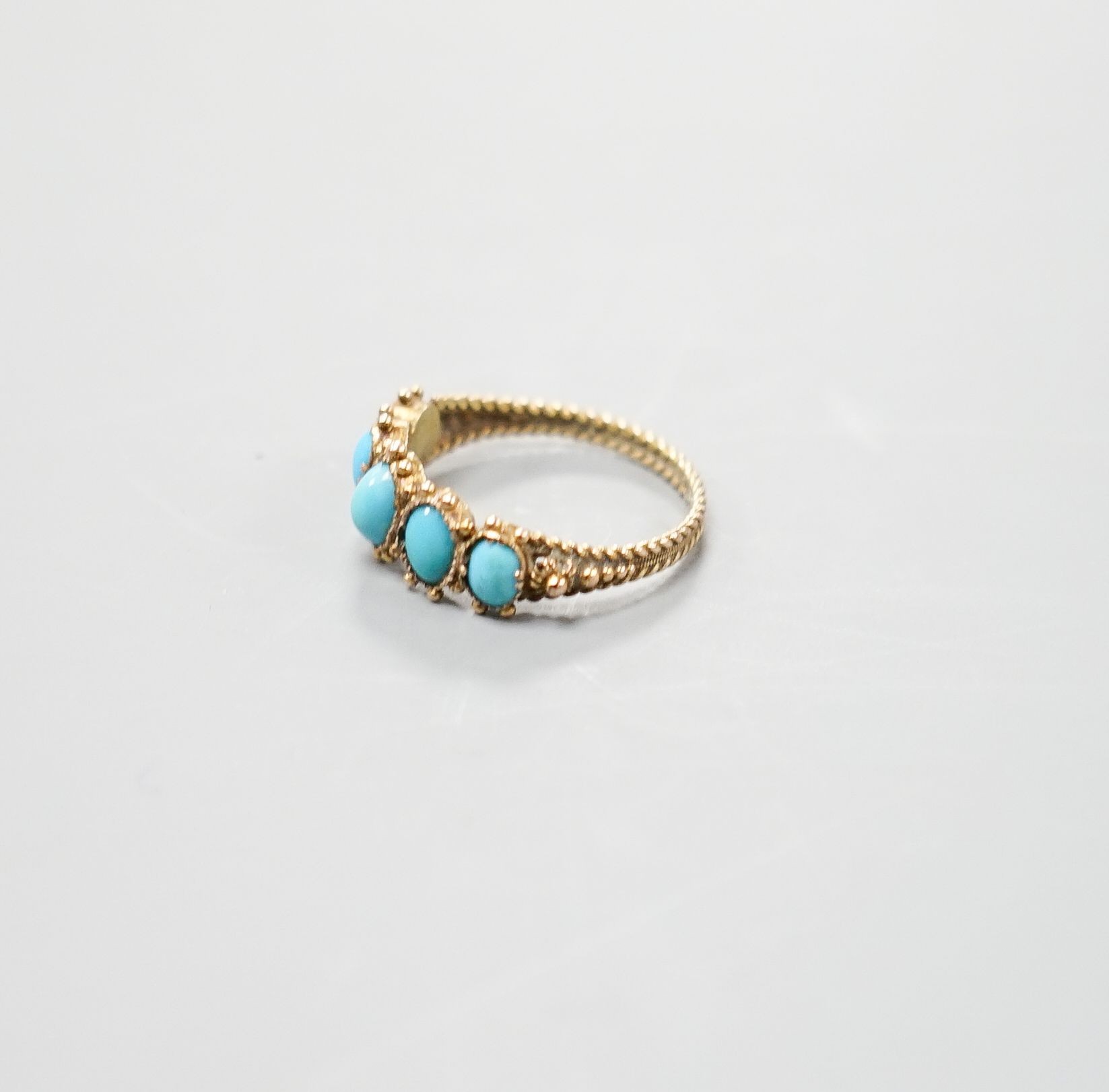 An early 19th century yellow metal and graduated five stone cabochon turquoise half hoop ring, size N, gross weight 1.9 grams.